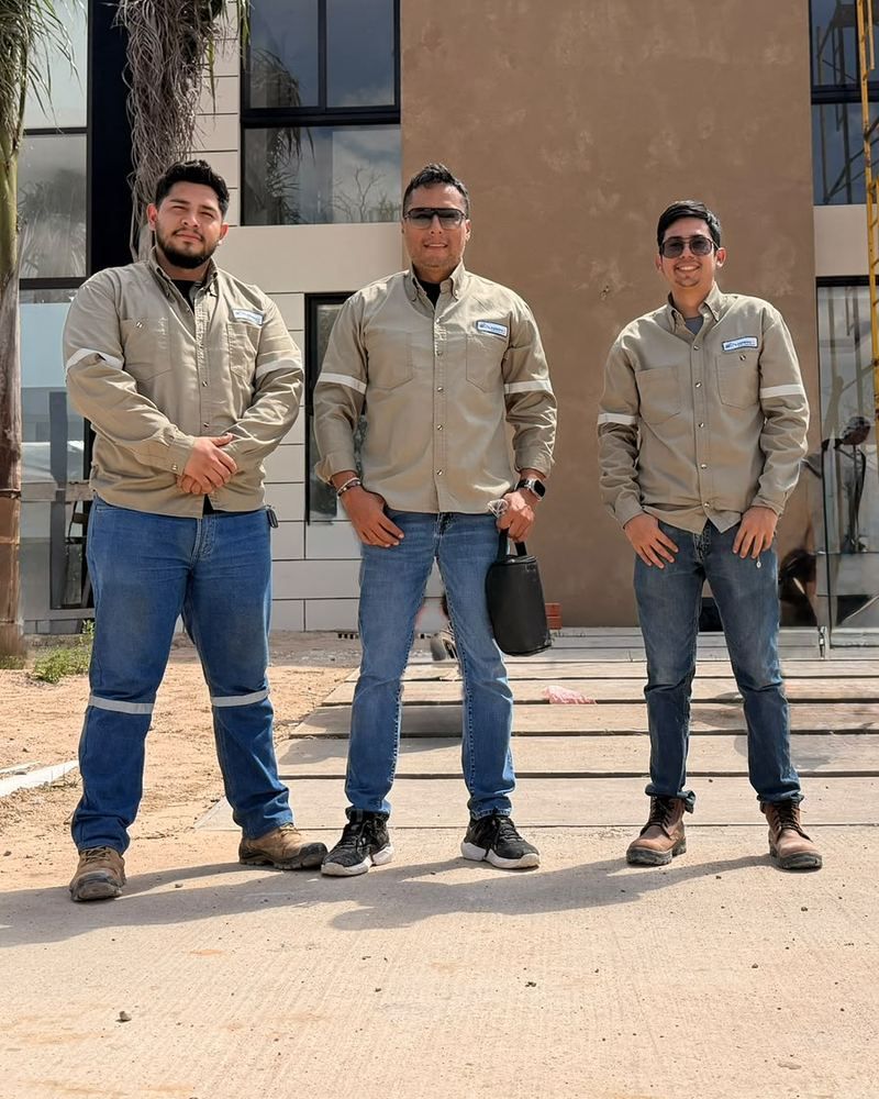 Equipo de construIA en obra frente a una vivienda en construcción